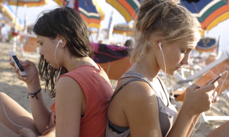 two girls on the beach listening to music