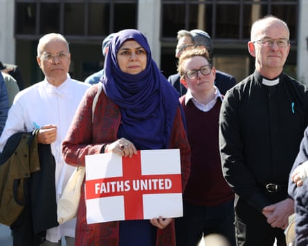 A woman in a headscarf holding a St George flag with the message ‘Faiths united’