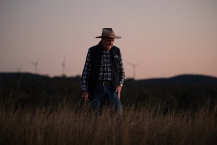 David Lawler in farmer gear in the evening light, windfarms in the background
