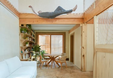 A narrow, well-lit living room with pine paneling.