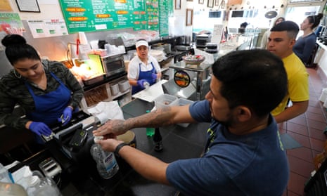 A customer uses sanitizer before picking up his order at Las Compadres Taqueria in Oakland, California.