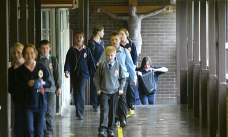 Pupils walk past a crucifix at a Catholic school. 