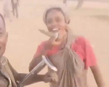 A blurred image of a smiling woman in a desert landscape holding what looks like a knife
