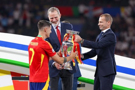 Álvaro Morata is handed the Euro 2024 trophy by King Felipe VI and Uefa’s President Aleksander Ceferin.