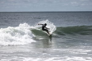 Samuel performs a turn while surfing in Robertsport