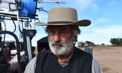 Man with hat, mustache and beard looks to his right