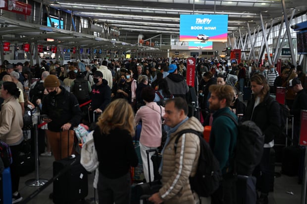 O mulțime de oameni care stau la coadă pentru a-și înregistra bagajele la un aeroport