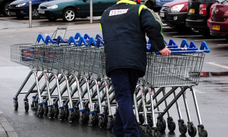 A Tesco employee collecting trolleys at a store in Burton upon Trent.