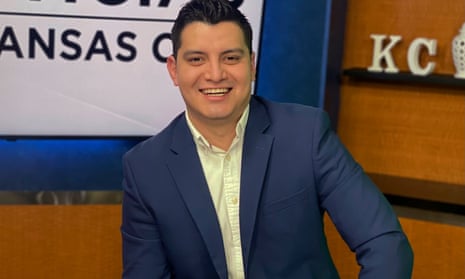 Adan Manzano, a television reporter, smiles in a blue suit in a studio