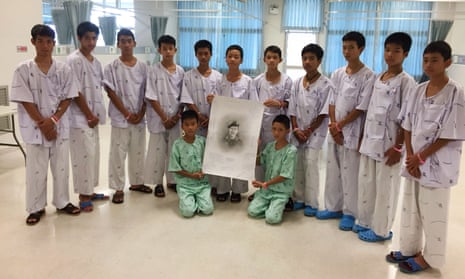 Members of Wild Boars football team after writing messages on a sketch of former navy Seal diver Saman Kunan who died during the mission to rescue them. 
