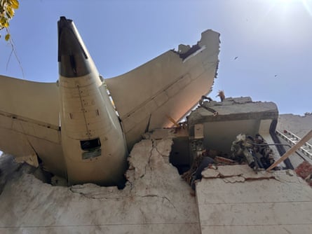 Tail of a plane sticking out of a concrete building