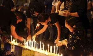 People light candles at the scene of a massive suicide truck bomb attack in Karada, Iraq.
