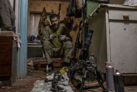 A soldier cleaning a machine gun 