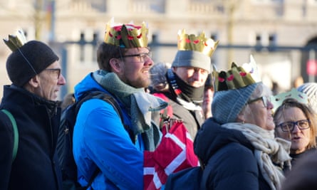 Members of the public wear fake crowns at Christiansborg Palace Square in Copenhagen before the proclamation of abdication of Queen Margrethe II