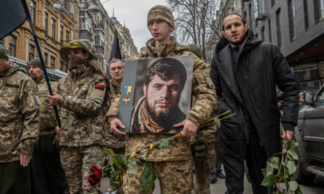 A soldier holds a picture of Dmytro Kotsiubailo