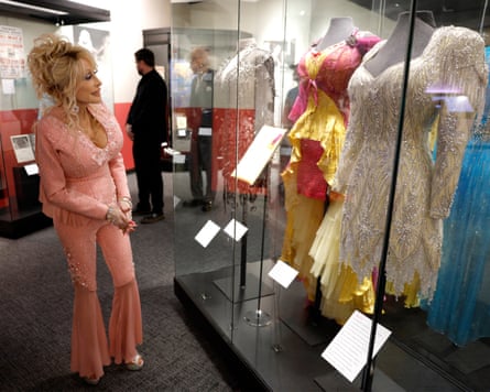 a woman stands in front of a display of costumes
