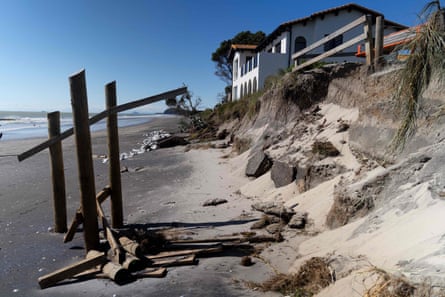 This picture shows a coastal home after part of its back garden and sand was washed away during the storm surge caused by Cyclone Gabrielle in Waihi Beach in the Bay of Plenty