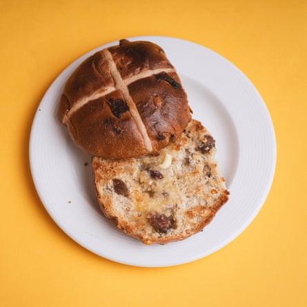 A Morrisons The Best lemon drizzle hot cross bun, sliced, toasted and buttered, on a white plate