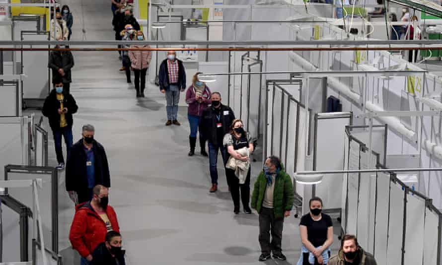 NHS staff and key workers queue for the coronavirus vaccine in Glasgow, Scotland.
