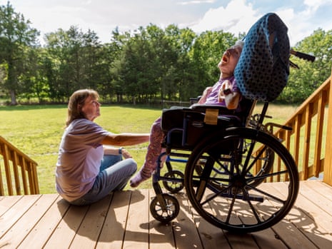 a woman sits on a stoop next to a woman in a wheelchair