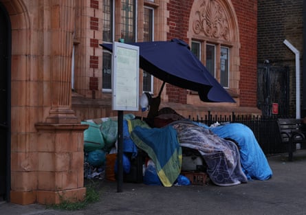 A makeshift shelter with umbrella and plastic bags