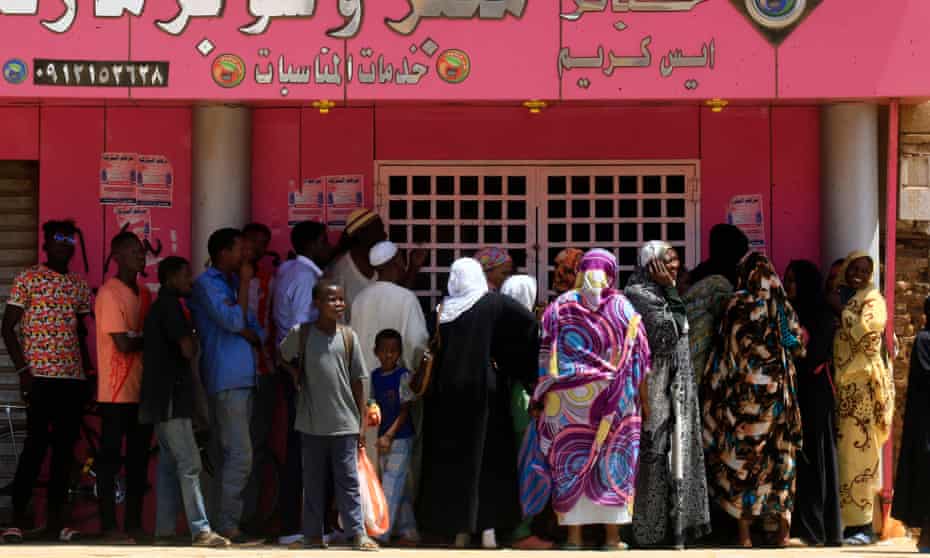 Sudanese people queue up outside a bakery