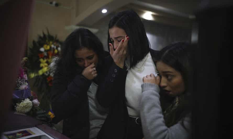Mourners of Marbella Valdez grieve over her casket during her wake at a funeral home in Tijuana on 14 February.