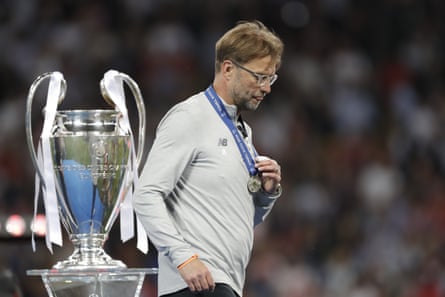 Klopp looks disappointed as he walks past the trophy after losing to Real Madrid in the Champions League final in 2018.
