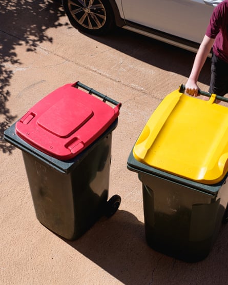 Red and yellow garbage bins being moved