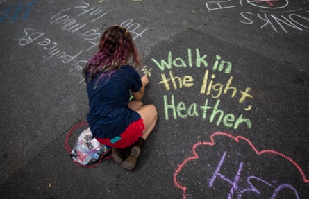 A woman writes messages in chalk in memory of Heather Heyer in Charlottesville, Virginia.