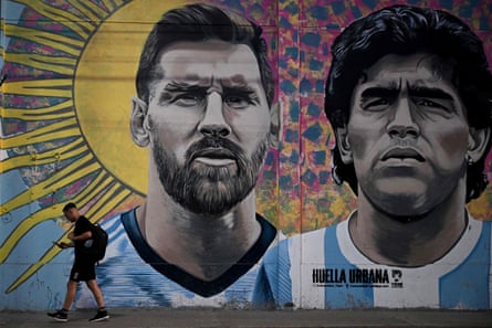 A man passes by a mural depicting Lionel Messi and Diego Maradona in Buenos Aires.