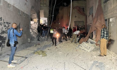 People inspect damage after the Israeli strike hit a compound beneath a mosque in Jenin refugee camp, West Bank