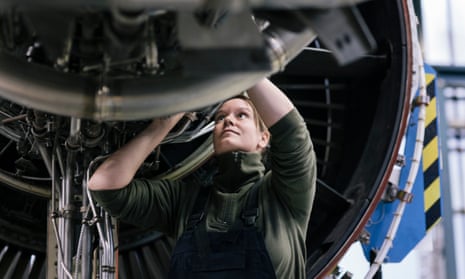 A female engineer works on a jet engine
