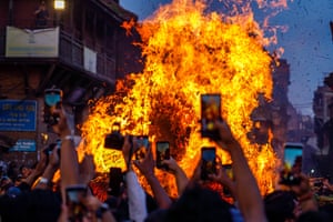 People record videos on their phones as the effigy is burned in a huge fire