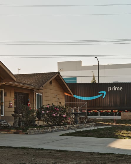 An Amazon Prime truck drives past a home across the street from a warehouse in Bloomington.
