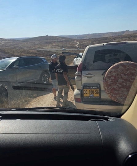 Armed men block a vehicle.