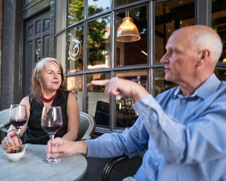 Becky and Andy sitting chatting at a small table outside the front of a restaurant