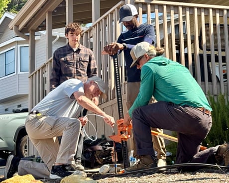People collect soil samples outside a home.