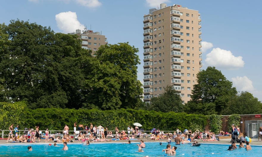 Brockwell lido in Brockwell Park, London, with tower blocks behind it.