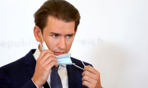 Austrian Chancellor Sebastian Kurz takes off a protective face mask as he arrives for a news conference in Vienna
