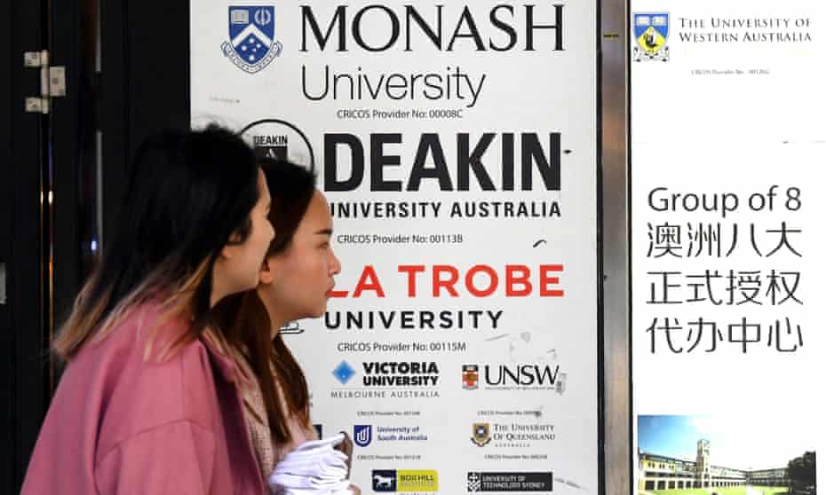 People walk past signage for Australian universities