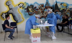 Health workers wear protective gear while collecting nasopharyngeal swab samples from senior high school students in Nicosia, Cyprus, 13 May 2020.