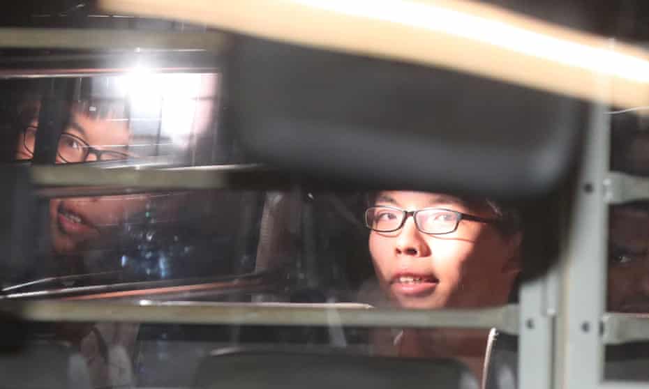 Protest leader Joshua Wong leaves Hong Kong’s high court in a prison van after his sentencing.