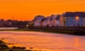 sunset reflected on the water on The Long Walk Galway.