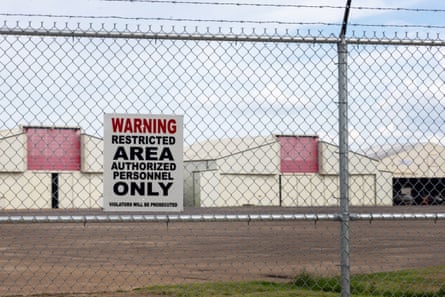 A warning sign hangs on a fence