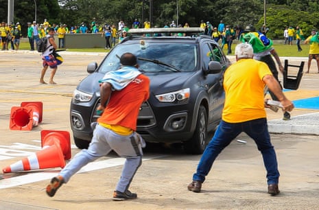 Supporters of Jair Bolsonaro attack a police vehicle outside the presidential palace in Brasilia, Brazil, on 8 January 2023.