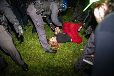 woman lies on ground as officer leans over her