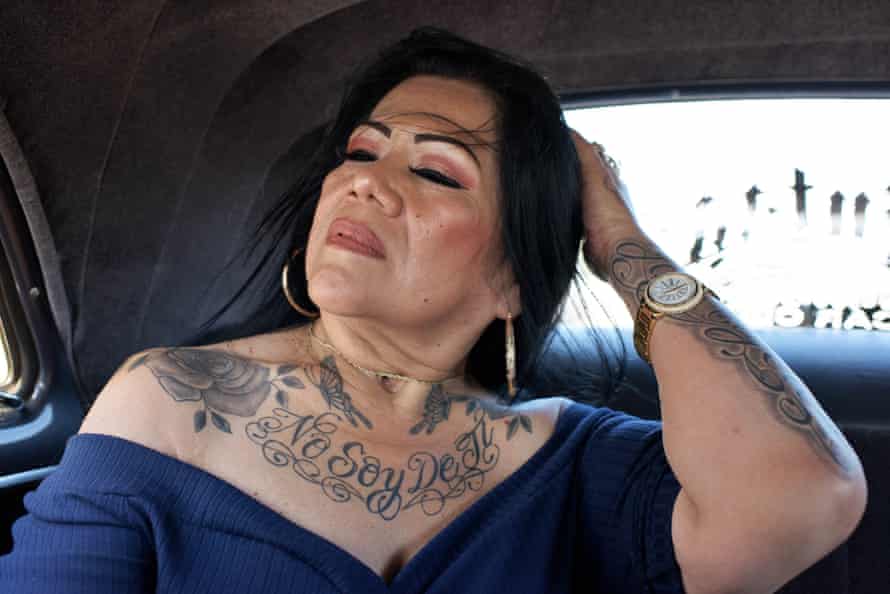 woman brushes hair back. She has tattoo saying "No soy de ti"