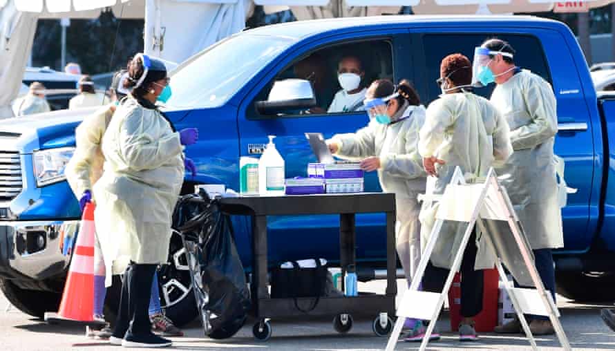 People pull up in their vehicles for Covid-19 vaccines in the parking lot of The Forum in Inglewood, California on January 19, 2021.