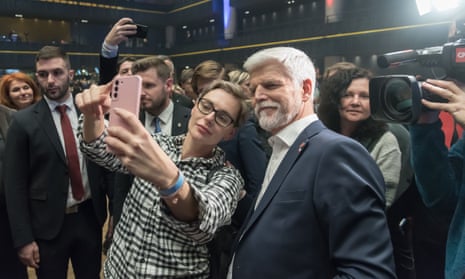 A supporter seen taking selfies using a mobile phone with the winner of Czech presidential elections Petr Pavel (R) in Prague.